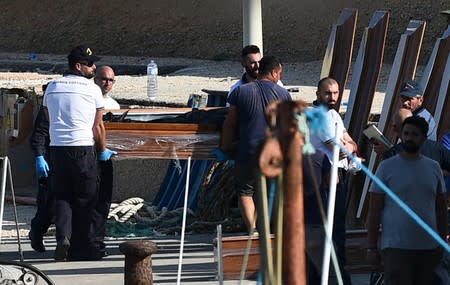 Emergency services carry a body from a migrant shipwreck that took place on October 7 back to the island of Lampedusa