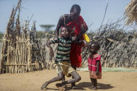 FILE - A mother helps her malnourished son stand after he collapsed near their hut in the village of Lomoputh in northern Kenya, Thursday, May 12, 2022. An international team of climate scientists says the ongoing drought in Eastern Africa has been made worse by human-induced climate change according to a report from World Weather Attribution. (AP Photo/Brian Inganga, File)