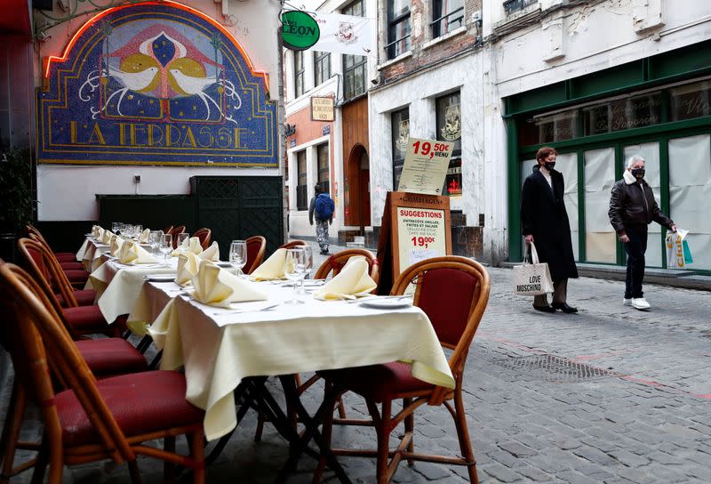 People past an empty terrace of a restaurant amid the coronavirus disease outbreak in Brussels