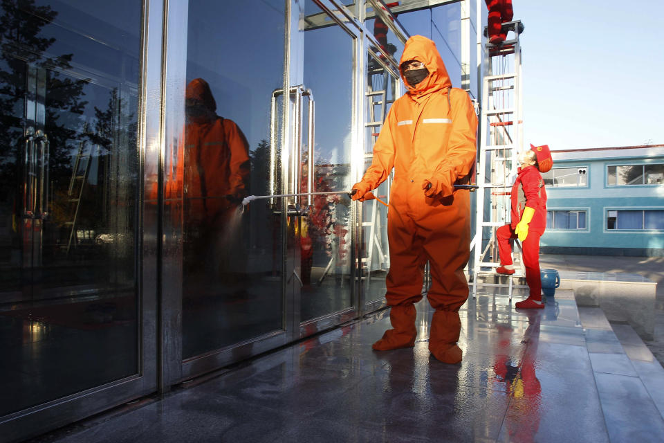 Hygienic and anti-epidemic officials disinfect the public walkway outside the Songdowon General Foodstuff Factory in the city of Wonsan, Kangwon Province, North Korea DPRK, on Wednesday, Oct., 28, 2020. (AP Photo/Jon Chol Jin)