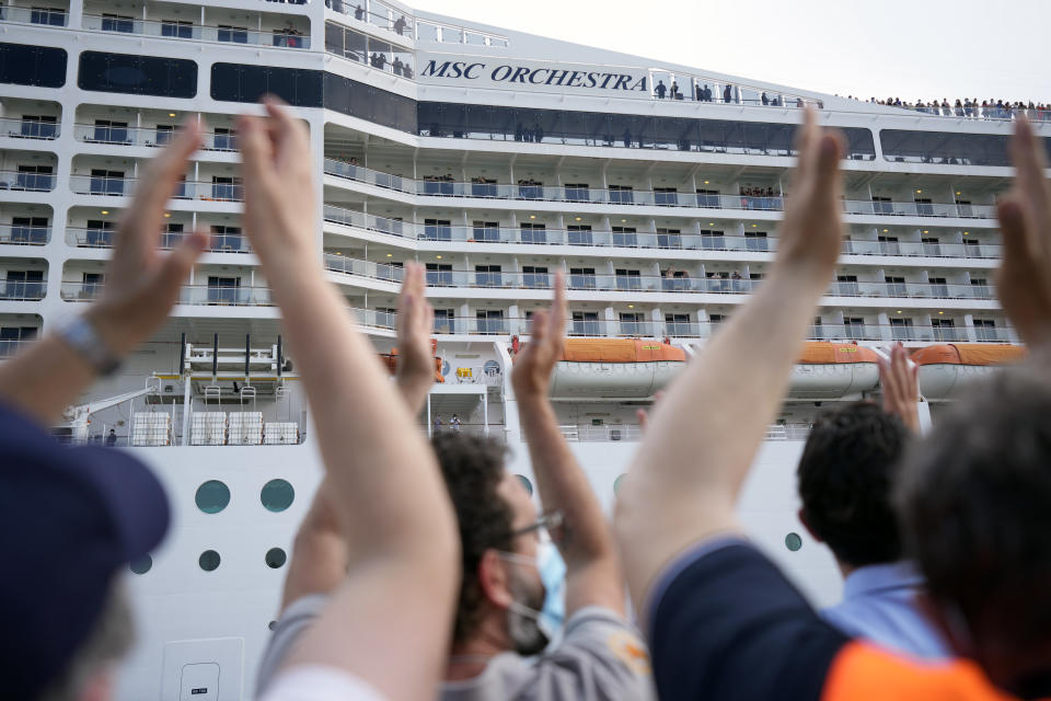 People applaud as the 92,409-ton, 16-deck MSC Orchestra cruise ship departs from Venice, Italy, Saturday, June 5, 2021. The first cruise ship leaving Venice since the pandemic is set to depart Saturday amid protests by activists demanding that the enormous ships be permanently rerouted out the fragile lagoon, especially Giudecca Canal through the city's historic center, due to environmental and safety risks. The cruiser passed two groups of protesters: pro-cruise advocates whose jobs depend on the industry as well as protesters belonging to a movement called "No Big Ships" who have been campaigning for years to get cruise ships out of the lagoon. (AP Photo/Antonio Calanni)