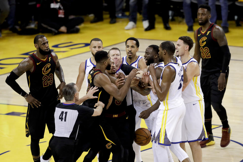 An official tries to separate Tristan Thompson and Draymond Green during overtime of Game 1 of the NBA Finals. (AP Photo/Marcio Jose Sanchez)