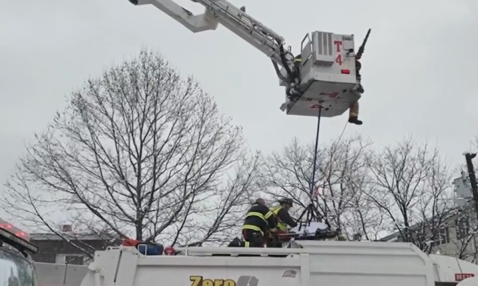 Firefighters later used a basket pulled by the fire truck crane to carefully hoist the woman to safety (Boston 25 News)