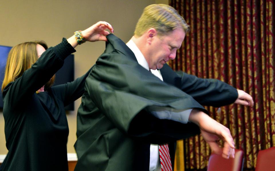 Stephanie Wilkinson helps her husband, Andrew, put on his judge's robes during the Jan. 10, 2020, investiture ceremony for the new Washington County Circuit Court judge.