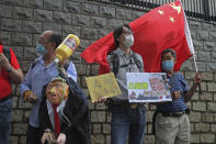 Pro-China supporters hold the effigy of U.S. President Donald Trump and Chinese national flag outside the U.S. Consulate during a protest, in Hong Kong, Saturday, May 30, 2020. President Donald Trump has announced a series of measures aimed at China as a rift between the two countries grows. He said Friday that he would withdraw funding from the World Health Organization, end Hong Kong's special trade status and suspend visas of Chinese graduate students suspected of conducting research on behalf of their government. The placard reads "Shameless, Donald Trump." (AP Photo/Kin Cheung)