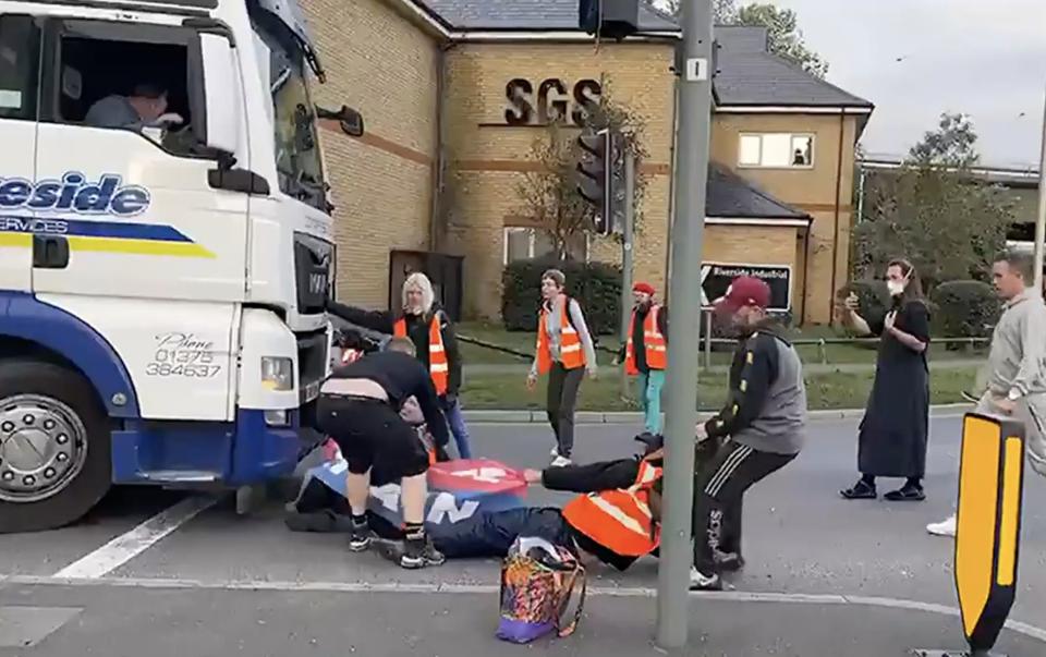 An Insulate Britain protester is dragged from the road by a driver - LBC