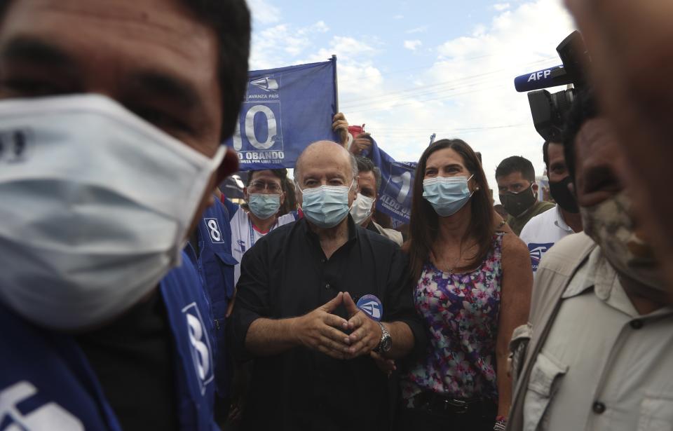 El candidato presidencial del partido Avanza País, Hernando De Soto, llega con su esposa Carla Olivieri a un evento de campaña en el barrio de chabolas de Villa El Salvador en las afueras de Lima, Perú, el lunes 5 de abril de 2021. Las elecciones generales de Perú están programadas para el 11 de abril. (AP Foto/Martin Mejia)