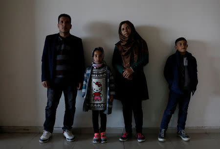 An Afghan migrant family pose at a bus terminal, as they struggle to find buses to take them to western Turkish cities, after crossing the Turkey-Iran border in Agri, eastern Turkey, April 11, 2018. Picture taken April 11, 2018. REUTERS/Umit Bektas