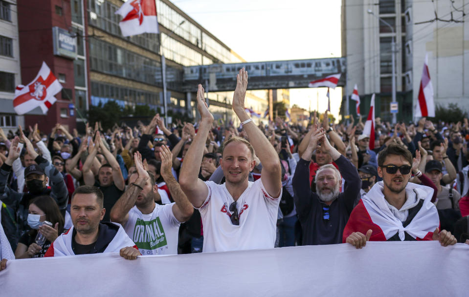 Protesters applaud a speaker during an opposition rally to protest the official presidential election results in Minsk, Belarus, Sunday, Sept. 20, 2020. Tens of thousands of Belarusians calling for the authoritarian president to resign marched through the capital on Sunday as the country's wave of protests entered its seventh week. Hundreds of soldiers blocked off the center of Minsk, deploying water cannon and armored personnel carriers and erecting barbed wire barriers. (AP Photo/TUT.by)