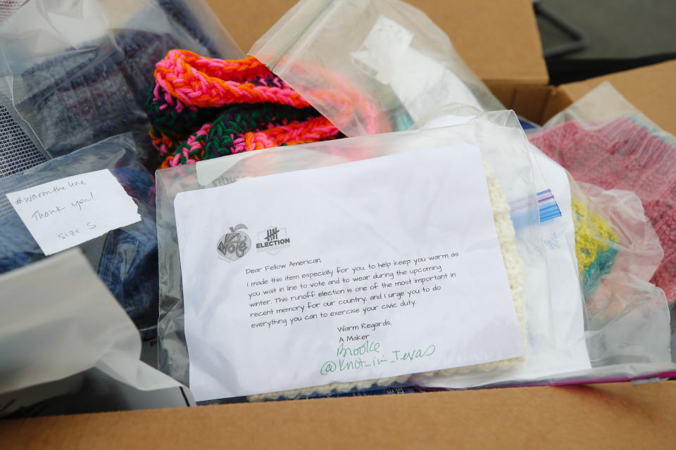 A note is included with a knitted hat to be given out to voters by Election Defender volunteers during early voting for the Senate runoff elections, at the Ron Anderson Recreation Center, Thursday, Dec. 17, 2020, in Powder Springs, Ga. (AP Photo/Todd Kirkland)