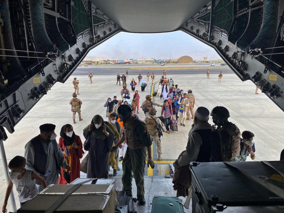 In this photo provided by the Spanish Defense Ministry and taken in Kabul, Afghanistan, people board a Spanish air force A400 plane as part of an evacuation plan at Kabul airport in Afghanistan, on Aug. 18, 2021.