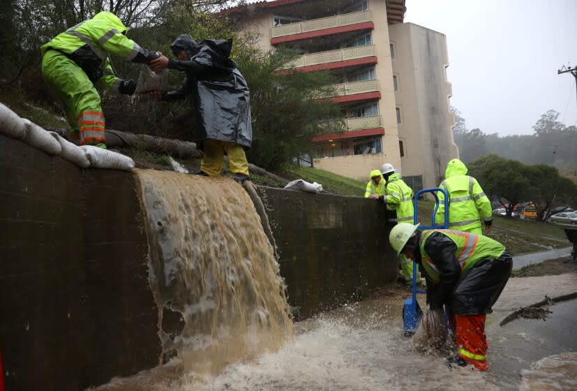 MARIN CITY, CALIFORNIA - OCTOBER 24: Workers try to divert water into drains as rain pours down on October 24, 2021 in Marin City, California. A Category 5 atmospheric river is bringing heavy precipitation, high winds and power outages to the San Francisco Bay Area. The storm is expected to bring anywhere between 2 to 5 inches of rain to many parts of the area. (Photo by Justin Sullivan/Getty Images)