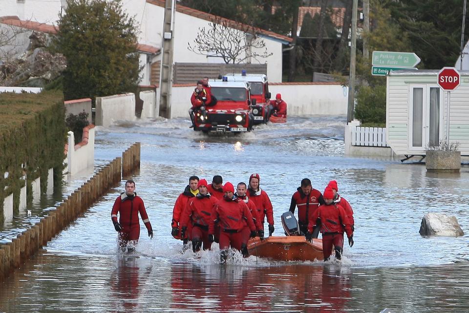 Firefighters wading in a flooded street of La Faute-sur-Mer as a result of a storm on March 1st, 2010.