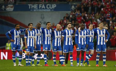 Wigan Athletic's players react during their penalty shoot-out against Arsenal during their English FA Cup semi-final soccer match at Wembley Stadium in London April 12, 2014. REUTERS/Eddie Keogh