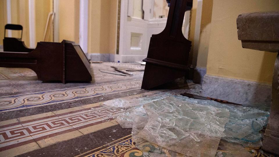 Overturned furniture and broken glass litter a hallway of the US Capitol in Washington, DC, on January 7, 2021, one day after supporters of outgoing President Donald Trump stormed the building.