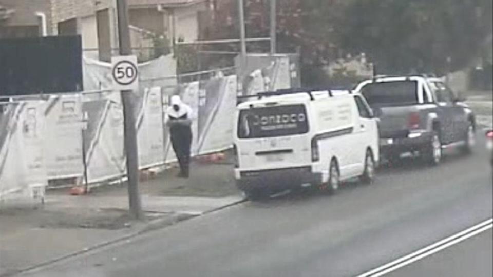 A hooded man walking past a construction site near where the Mini was planted earlier in the day is of interest to the police. Picture: NSW Police