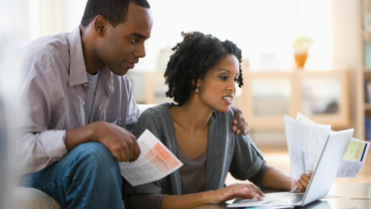 Couple paying bills using laptop.