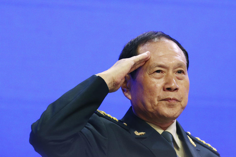 FILE - In this June 2, 2019, file photo, Chinese Defense Minister Gen. Wei Fenghe salutes attendees ahead of the fourth plenary session of the 18th International Institute for Strategic Studies (IISS) Shangri-la Dialogue, in Singapore. China's defense minister has warned that its military will "resolutely take action" to defend Beijing's claims over self-ruled Taiwan and disputed South China Sea waters. (AP Photo/Yong Teck Lim, File)