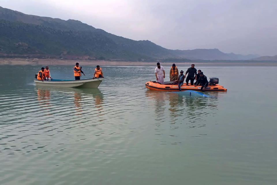 In this photo provided by Khyber Pakhtunkhwa's provincial rescue department 'Rescue 1122', rescue workers search bodies following a boat caspisdwe in Tanda lake, in Kohat, in the northwest Pakistan, Sunday, Jan. 29, 2023. Some students who were on a picnic drowned after their boat capsized in a lake in Pakistan's northwest on Sunday, police said. (Emergency Service Rescue 1122 via AP)