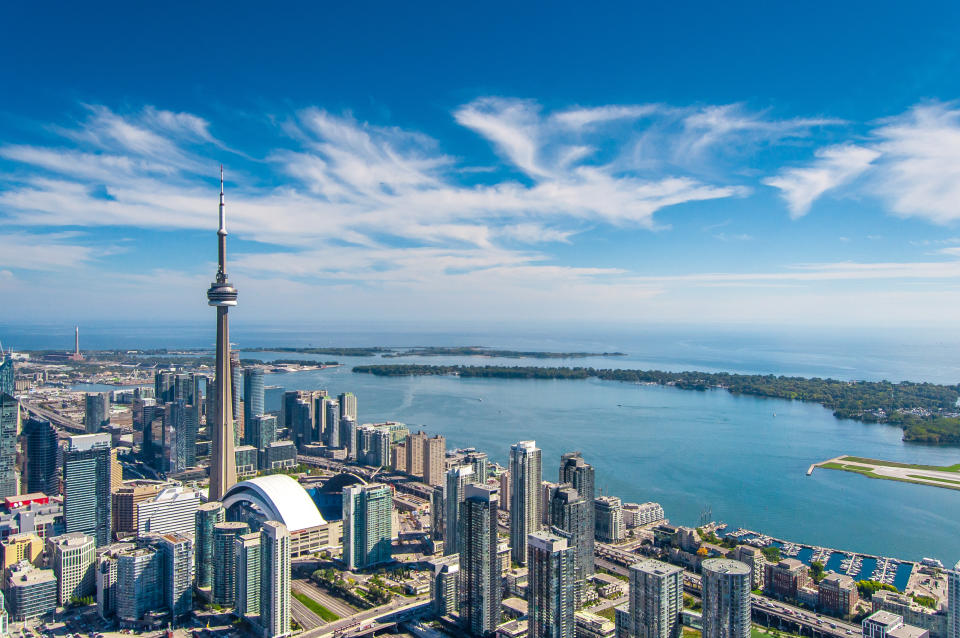 A photo of downtown Toronto taken from a helicopter facing southeast. The CN Tower features prominently in this photo which overlooks Lake Ontario.