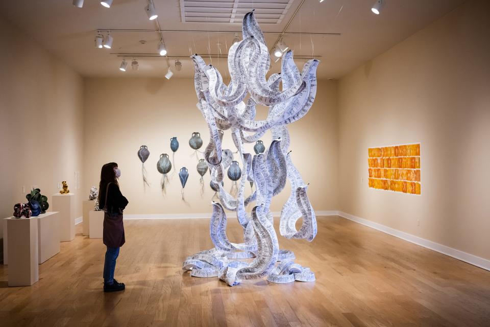 Gianna Paladin, an art student at Hampshire College, views Eric and Martin Demaine's "Diagram of a Cosmic Being II, 2022" currently on display as part of "Paper Town" at Fitchburg Art Museum on Sunday April 02, 2023.