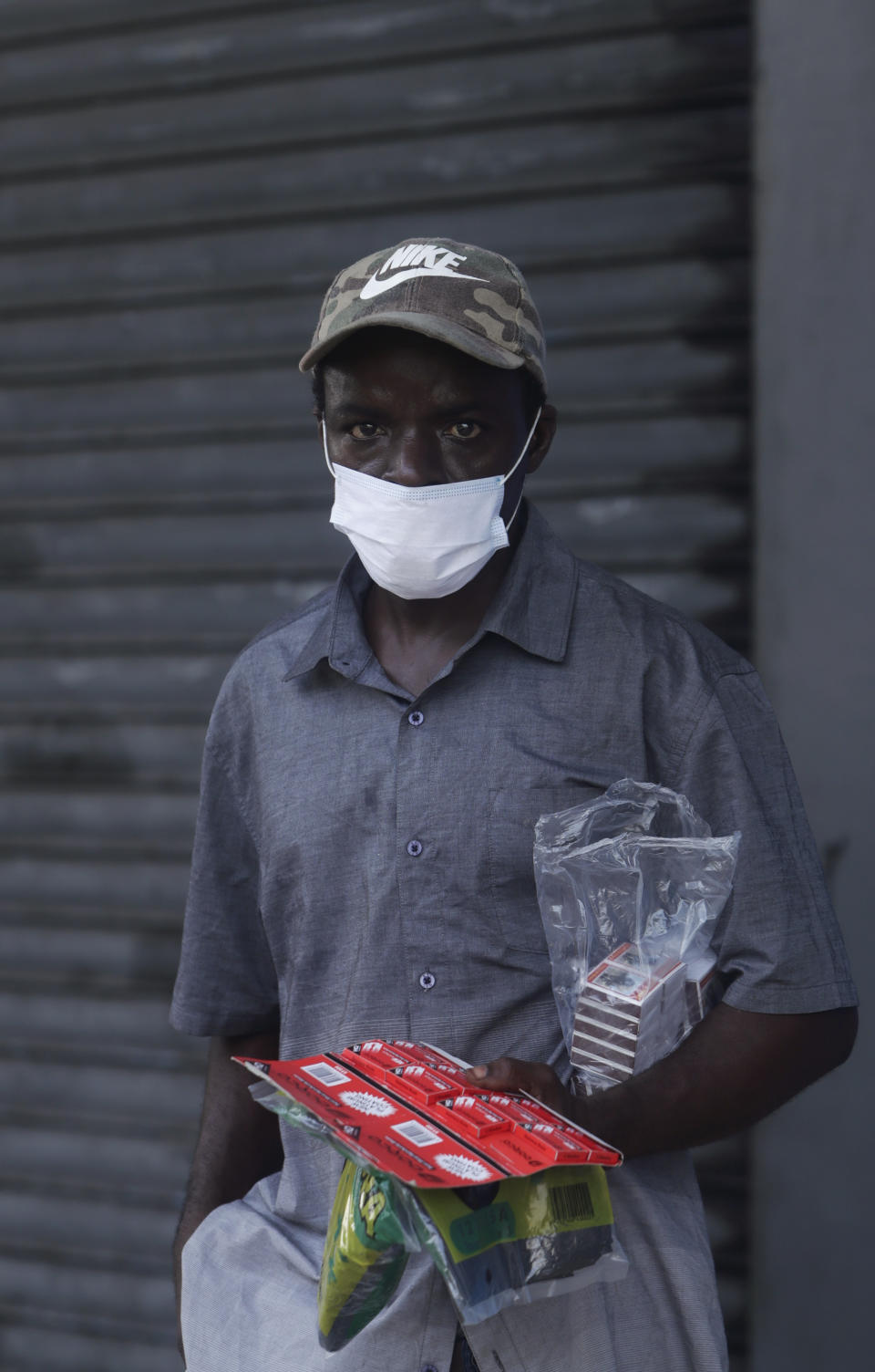 A street vendor wears a mask amid the new coronavirus pandemic as he sells matches, razor blades, and trash bags in Panama City, Monday, June 1, 2020. The Central American country reactivated a second block of activities on Monday, significantly easing mobility restrictions in place since March. (AP Photo/Arnulfo Franco)