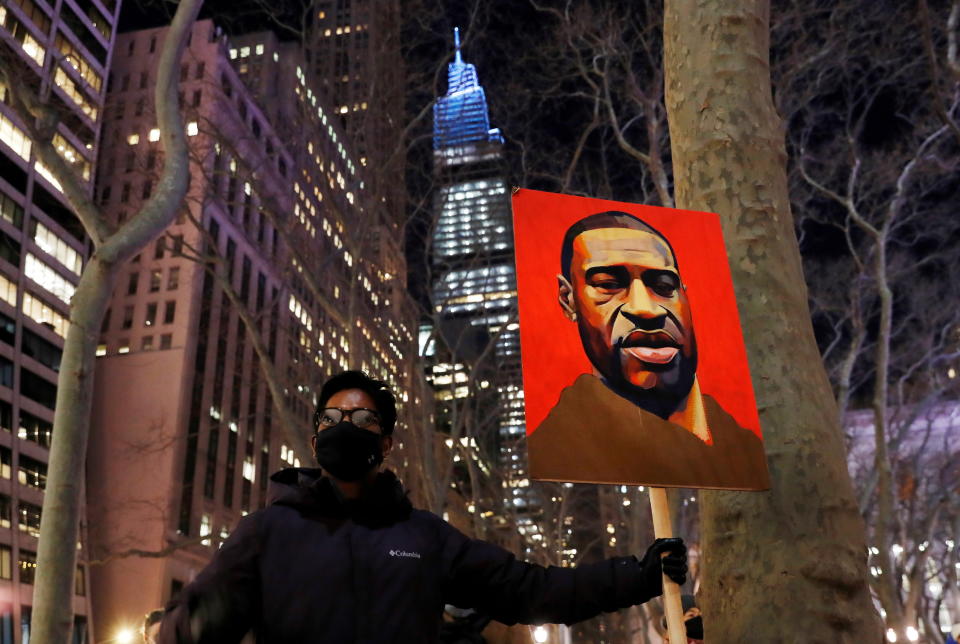 A demonstrator holds up an image of George Floyd during a rally on the first day of the trial of former Minneapolis police officer Derek Chauvin, on murder charges in the death of Floyd, in New York City, New York, U.S., March 8, 2021. REUTERS/Shannon Stapleton     