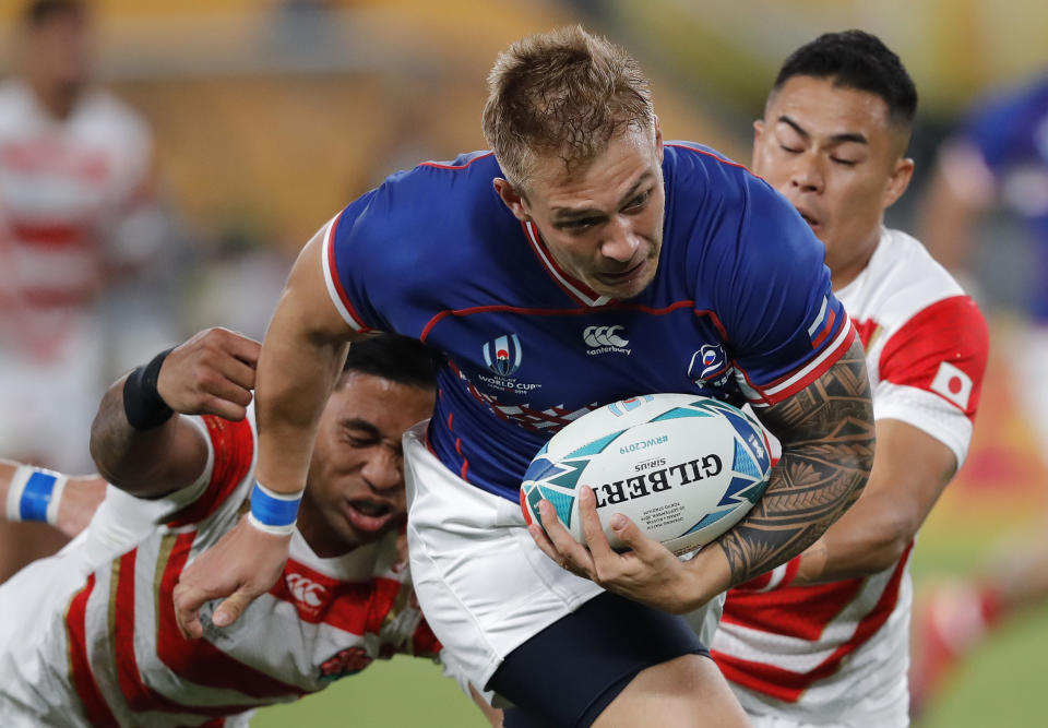 Russia's Kirill Golosnitskiy breaks through to score the opening try during the Rugby World Cup Pool A game at Tokyo Stadium between Russia and Japan in Tokyo, Japan, Friday, Sept. 20, 2019. (AP Photo/Christophe Ena)