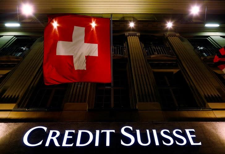 The logo of Swiss bank Credit Suisse is seen below the Swiss national flag at a building in the Federal Square in Bern, Switzerland May 15, 2014. REUTERS/Ruben Sprich/File Photo