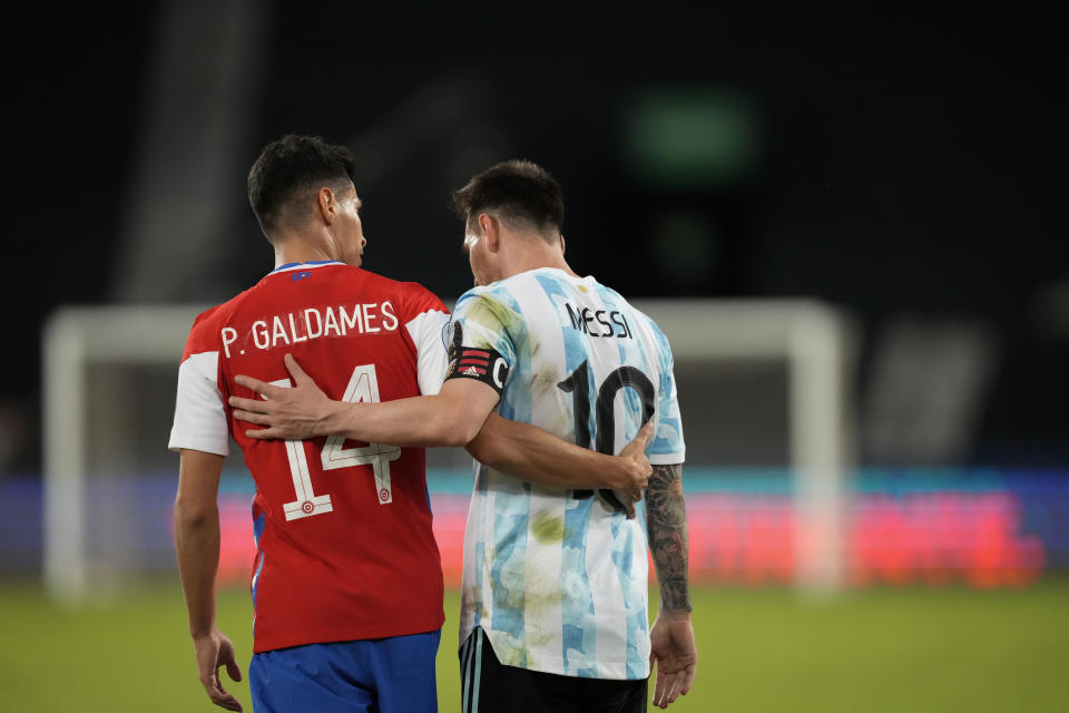 Chile's Pablo Galdames, left, and Argentina's Lionel Messi leave the field after a tie at the end of a Copa America soccer match at the Nilton Santos stadium in Rio de Janeiro, Brazil, Monday, June 14, 2021. The match enede 1-1.(AP Photo/Ricardo Mazalan)