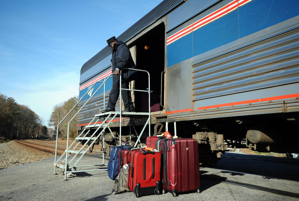 An Amtrak employee walks off a train car after the Amtrak Crescent train derailed, Monday, Nov. 25, 2013, in Spartanburg County, S.C. Several cars of the New York City-bound train with 218 people aboard went off the tracks early Monday as bags flew and jolted passengers clung to each other, authorities and passengers said. There were no serious injuries. (AP Photo/Rainier Ehrhardt)