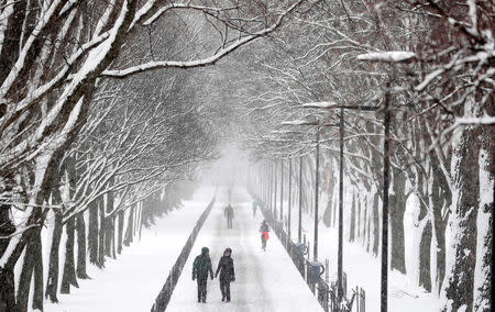 People make their way along the National Mall during a snowstorm in Washington, U.S., March 21, 2018. REUTERS/Kevin Lamarque