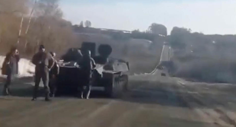 The Russian soldiers stand in front of their tank as they're approached by Ukrainian civilians. Source: Twitter