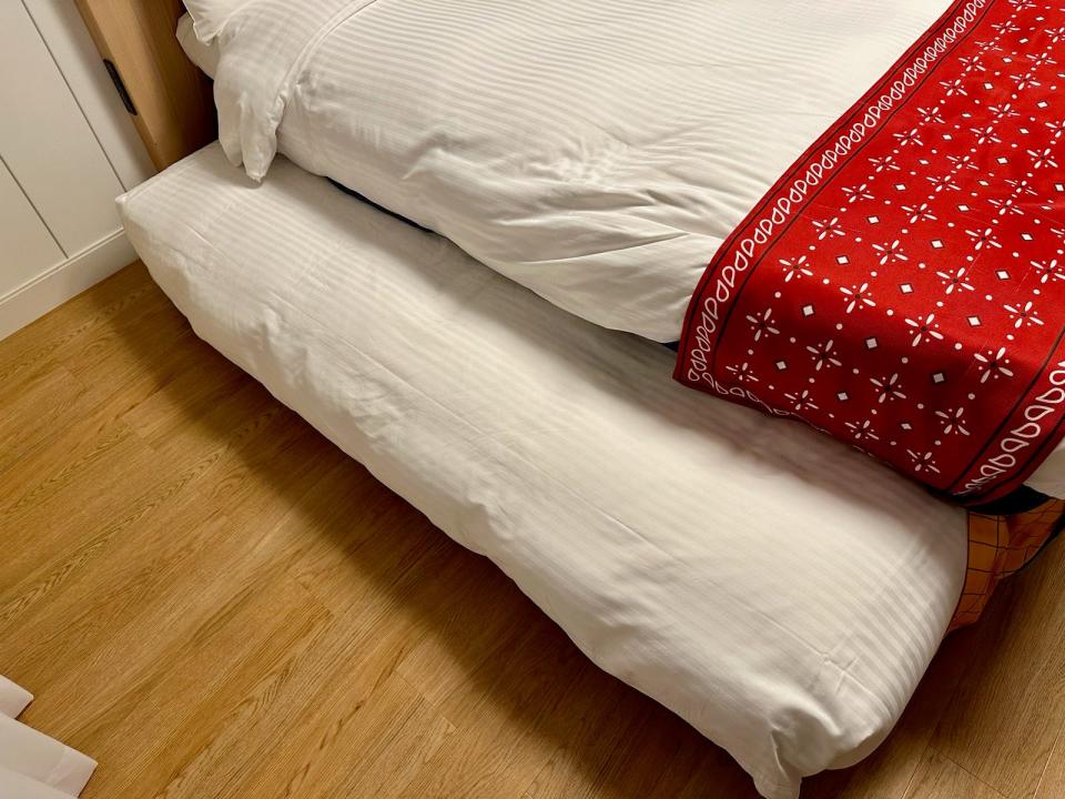 A roll-away cot tucked under a bed at Tokyo's Toy Story Hotel.