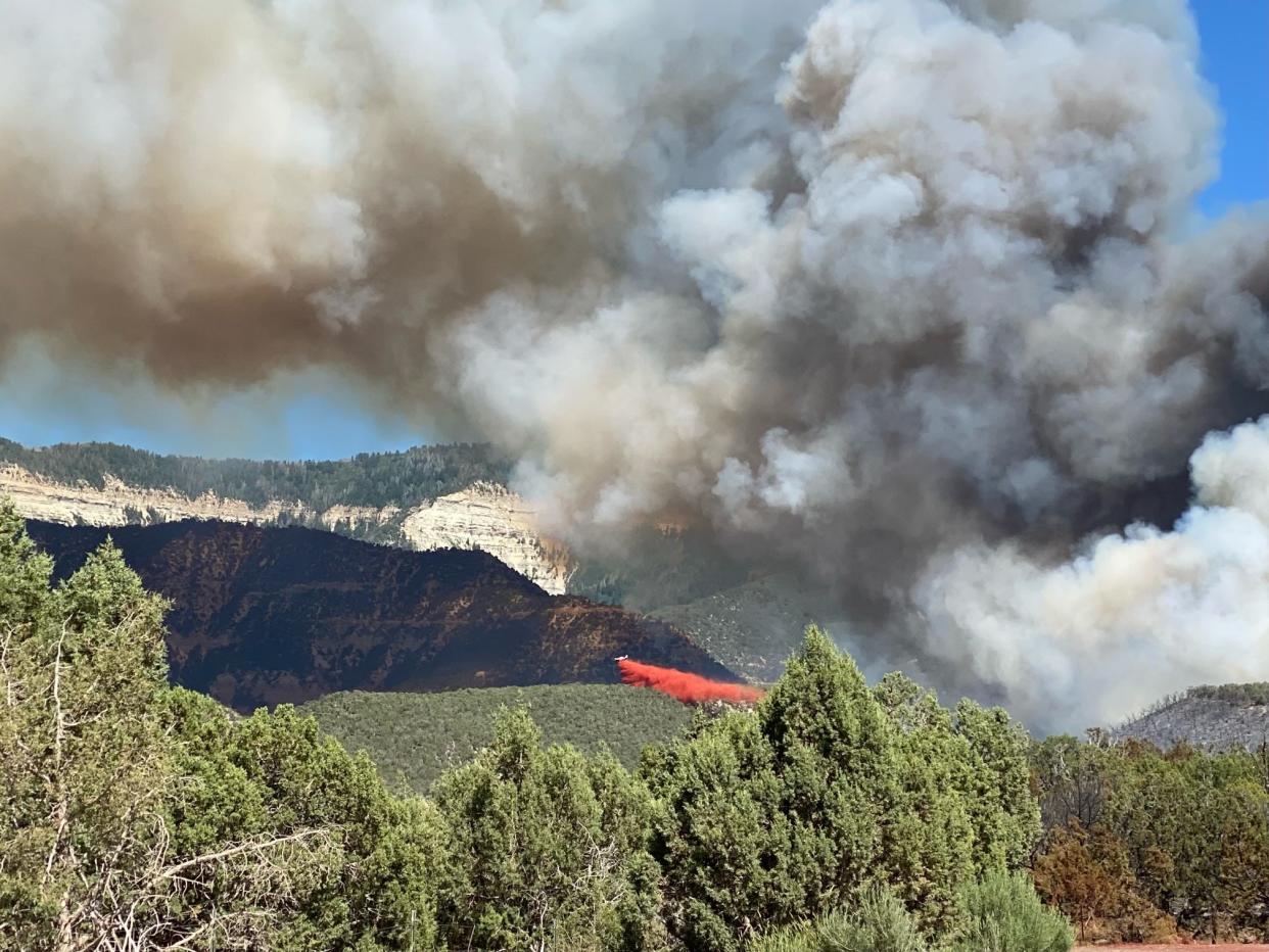 Firefighting aircraft drops slurry on the Spring Creek Fire burning near Parachute, Colo., on Monday, June 26, 2023.