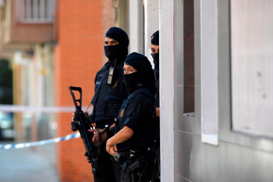 Catalan police stand guard outside the apartment of a building of the man who tried to attack the station (AFP/Getty Images)