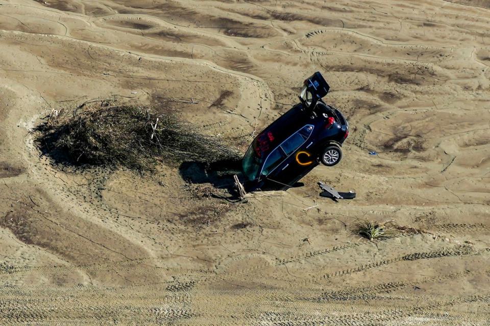 A car stuck in sand is seen in the aftermath of Cyclone Gabrielle in the Esk Valley near Napier on 18 February (AFP via Getty)
