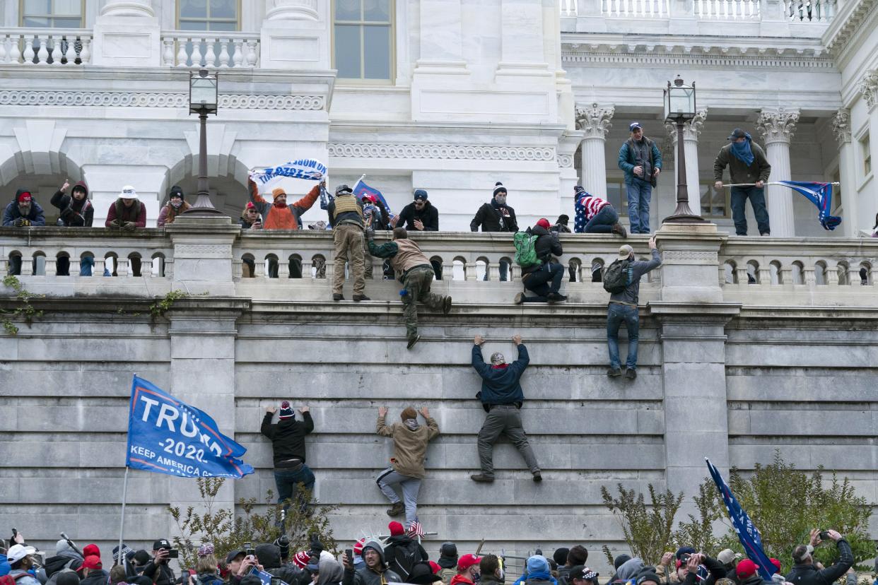 FILE - In this Jan. 6, 2021 file photo, violent insurrectionists loyal to President Donald Trump scale the west wall of the the U.S. Capitol in Washington. In the nearly nine months since Jan. 6, federal agents have managed to track down and arrest more than 600 people across the U.S. believed to have joined in the riot at the Capitol. Getting those cases swiftly to trial is turning out to be an even more difficult task.  (AP Photo/Jose Luis Magana, File)