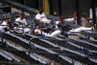 Arizona Diamondbacks players sit in the stands during the first inning of a baseball game against the Houston Astros Thursday, Aug. 6, 2020, in Phoenix. (AP Photo/Matt York)