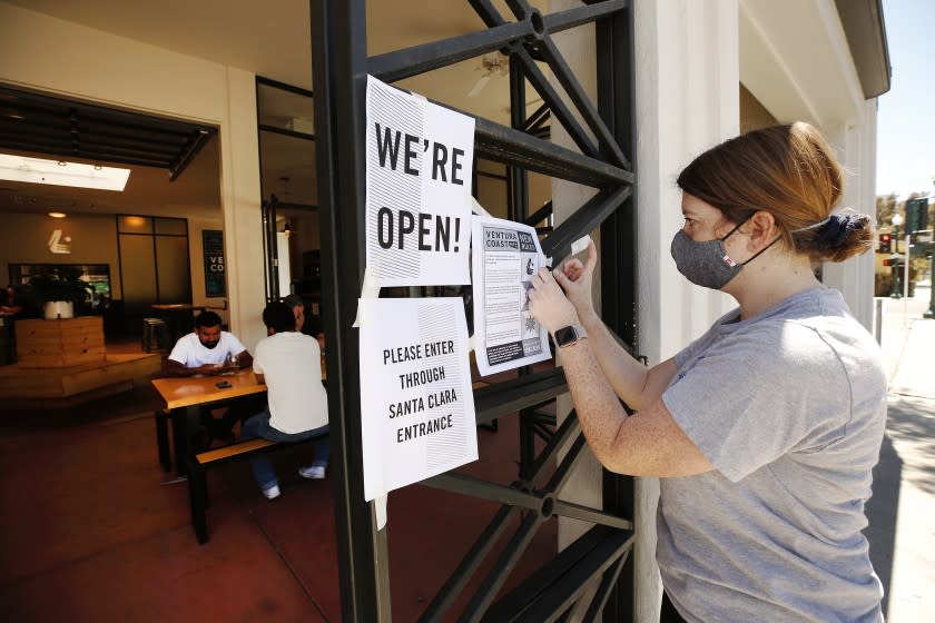 VENTURA, CA - MAY 21: Morgan Eales, girlfriend of owner/founder Kyle Thille posts new signs of opening at Ventura Coast Brewing Company on the corner of South Oak Street and East Santa Clara St in downtown Ventura as Ventura County has become the largest county in Southern California to resume dine-in service at restaurants and in-store shopping joining a growing list of California counties that have been given permission to enter phase two of reopening after closures due to coronavirus Covid-19. Downtown on Thursday, May 21, 2020 in Ventura, CA. Downtown on Thursday, May 21, 2020 in Ventura, CA. (Al Seib / Los Angeles Times)