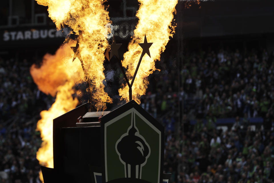 Fire effects go off behind two stars signifying the Seattle Sounders' two MLS Cup championship victories at the start of their season-opening MLS soccer match against the Chicago Fire, Sunday, March 1, 2020, in Seattle. The Sounders won the MLS Cup in 2016 and 2019. (AP Photo/Ted S. Warren)