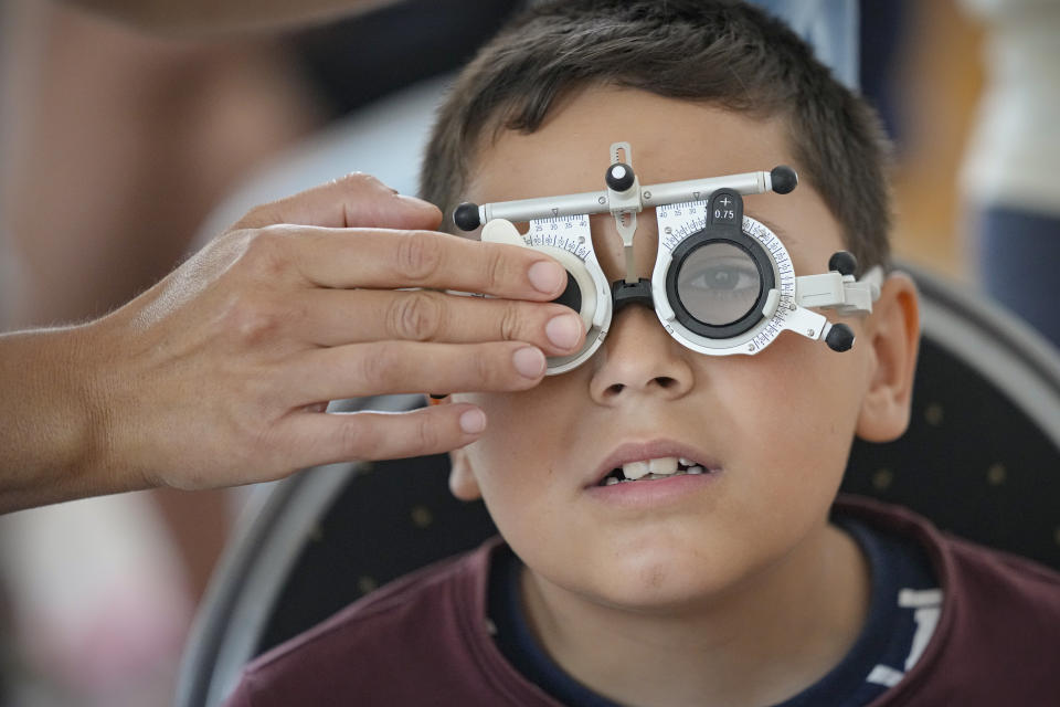 A boy undergoes an eyesight examination performed by volunteer ophthalmologists, in Nucsoara, Romania, Saturday, May 29, 2021. Dozens of disadvantaged young Romanian children got a chance to get their eyesight examined for the first time in their lives during an event arranged by humanitarian organization Casa Buna, or Good House, which has played a prominent role in supporting the local children's lives throughout the pandemic. (AP Photo/Vadim Ghirda)