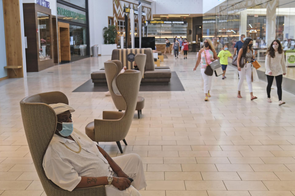 Shoppers walk around Garden State Plaza mall in Paramus, N.J., Monday, June 29, 2020. New Jersey's indoor shopping malls reopened on Monday from their COVID-19 pause. Democratic Gov. Phil Murphy set the date earlier this month after he shuttered many sectors of the state's economy because of the outbreak. (AP Photo/Seth Wenig)