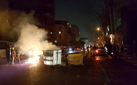 People protest in Tehran, Iran - Credit: Reuters