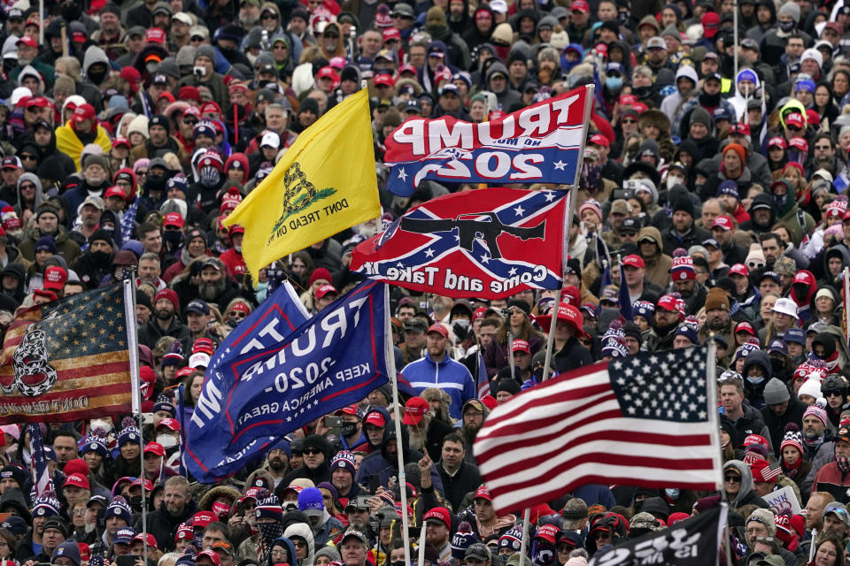 FILE - In this Jan. 6, 2021, file photo, supporters listen to President Donald Trump speak as flags, including a Confederate-themed one, flutter in the wind during a rally in Washington. (AP Photo/Evan Vucci, File)