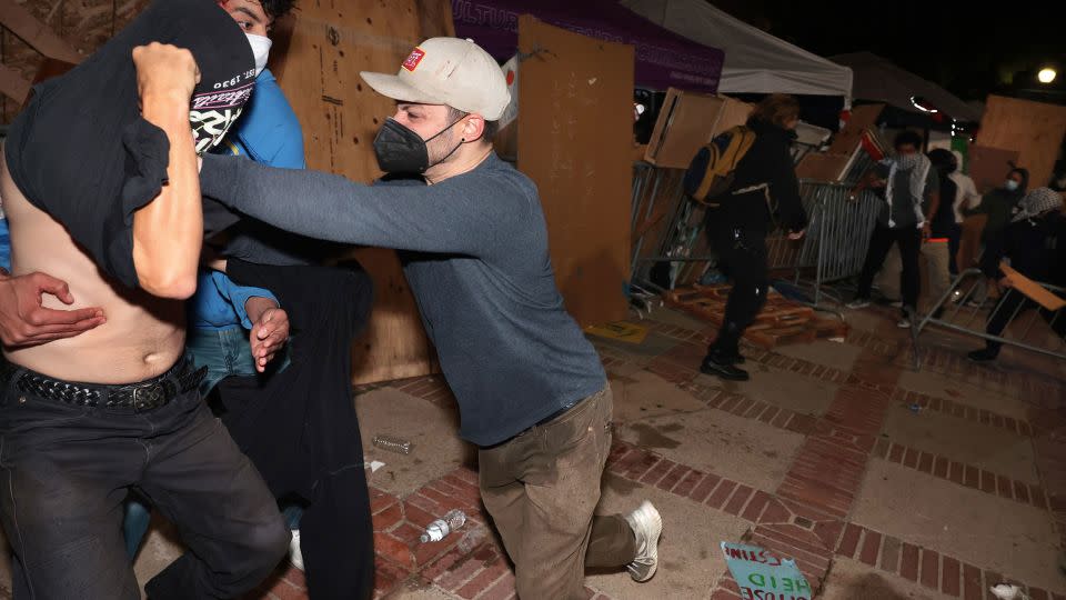 A counterprotester, identified by CNN as Malachi Marlan-Librett, pushes a pro-Palestinian protester in the barrier of the UCLA encampment. - Wally Skalij/Los Angeles Times/Getty Images