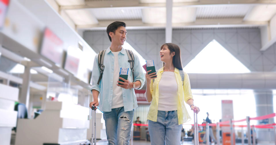 Asian couple chat happily sharing information while walking at the airport