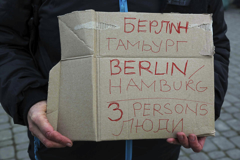 German Tanja Shwarcz, 51, holds a sign offering shelter in Hamburg, Germany to Ukrainian refugees arriving at the Medyka border crossing, Poland, Saturday, Feb. 26, 2022. (AP Photo/Visar Kryeziu)