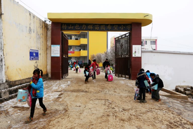 Students carry donated stationery at Zhuanshanbao Hope Primary School in Ludian, China's south-western Yunnan province, on January 11, 2018