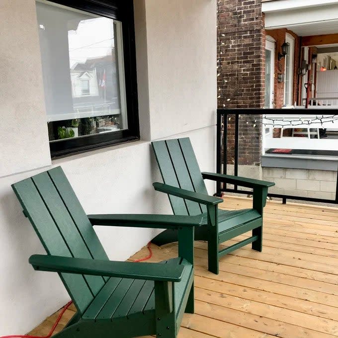 Reviewer's photo of the Adirondack chairs in the color Green on a porch